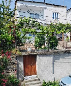 una casa con una puerta de madera y algunas flores en Lake Ohrid Guesthouse "Villa Valentina", en Pogradec