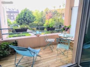 a balcony with chairs and a table on a balcony at Appartement de charme, Garage, Terrasse, Piscine in Lyon