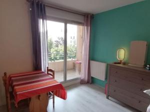 a room with a large window and a dresser and a bedroom at Appartement de charme, Garage, Terrasse, Piscine in Lyon