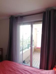 a bedroom with a window with a view of a deck at Appartement de charme, Garage, Terrasse, Piscine in Lyon +12 photos