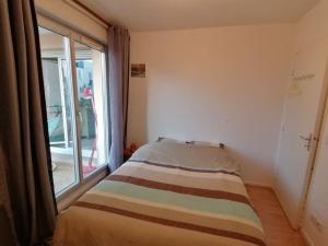 a bed in a room with a large window at Appartement de charme, Garage, Terrasse, Piscine in Lyon