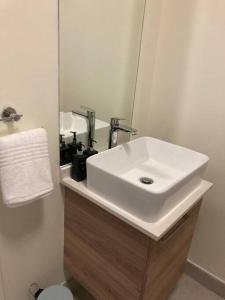 y baño con lavabo blanco y espejo. en Luxury 1bed Serengeti OliveWood ORT Airport en Kempton Park