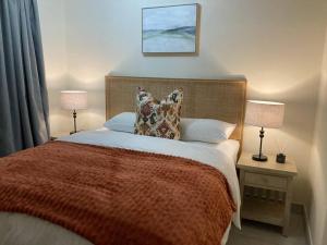 een slaapkamer met een groot bed met kussens en 2 lampen bij Luxury 1bed Serengeti OliveWood ORT Airport in Kempton Park