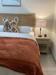 een slaapkamer met een bed en een tafel met een lamp bij Luxury 1bed Serengeti OliveWood ORT Airport in Kempton Park