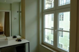 a bathroom with a window and a sink and a mirror at Liberator Rossio in Lisbon