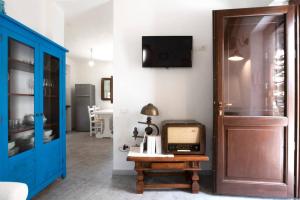 Cette chambre dispose d'une porte bleue et d'une télévision murale. dans l'établissement Casa tipica nel borgo antico, à Armungia