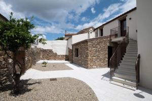 - un bâtiment en pierre avec un escalier à côté d'une maison dans l'établissement Casa tipica nel borgo antico, à Armungia