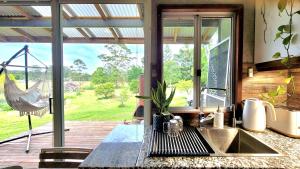 a kitchen with a sink and a large window at Rusty's Hideaway - Adorable tiny house on a beautiful farm in Moorland