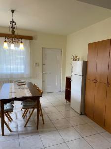 a kitchen with a table and a white refrigerator at SISSOU VILLAGe PLACe in Kalamata