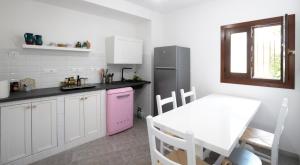 a kitchen with a pink oven and a table at Casa tipica nel borgo antico in Armungia