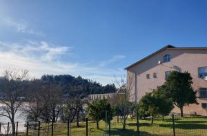 ein Gebäude mit einem Zaun neben einem Wasserkörper in der Unterkunft Apartamento Vistas Pedrido in Paderne