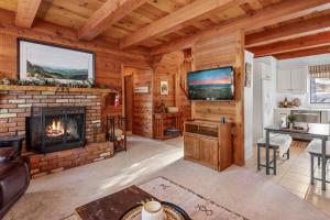 a living room with a fireplace in a log cabin at The Lakehouse Cabin - Located close to the Lake! Hot Tub, Smart TV, and WiFi! in Big Bear Lake