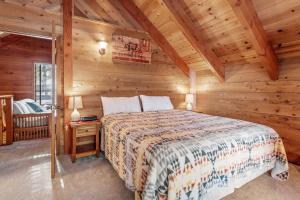 a bedroom with a bed in a log cabin at The Lakehouse Cabin - Located close to the Lake! Hot Tub, Smart TV, and WiFi! in Big Bear Lake