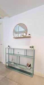 uma prateleira com um espelho numa parede branca em CLASSY HOMES - Acquamarina em Sanremo