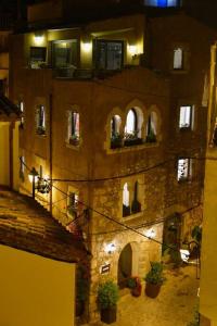 an old building with potted plants and windows at night at Can Senio 3 in Tossa de Mar