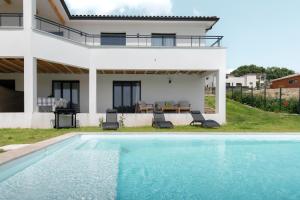 una villa con piscina di fronte a una casa di Les Coteaux de Toulouse a Aureville