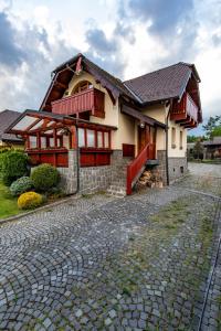 a house with a cobblestone street in front of it at Tatryhome - dom in Veľký Slavkov