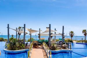 een resort met een pier met stoelen en de oceaan bij SOL Y MAR in Torrevieja