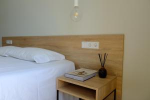 a bedroom with a bed and a nightstand with a book at Liberator Rossio in Lisbon