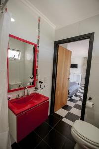 uma casa de banho com um lavatório vermelho e um WC. em La vie en rose em San Bernardo