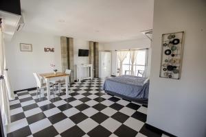 a bedroom with a checkered floor and a bed and a table at La vie en rose in San Bernardo