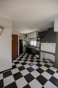 uma cozinha com piso em xadrez preto e branco em La vie en rose em San Bernardo