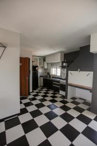 Una cocina con suelo a cuadros en blanco y negro. en La vie en rose, en San Bernardo
