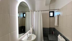 a bathroom with a sink and a shower with a mirror at 100 meters from the sea in Xylokastron +25 photos