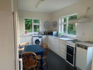 a kitchen with white cabinets and a blue table at Cooper Hill R93R209 in Carlow