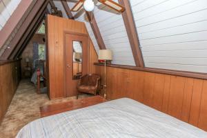 an attic bedroom with a bed and a chair at The Getaway - Amazing and cozy escape! With beautiful views of the Bear Mountain slopes! in Big Bear Lake