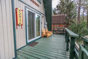 a wooden porch with a bench on the side of a house at The Getaway - Amazing and cozy escape! With beautiful views of the Bear Mountain slopes! in Big Bear Lake +5 photos