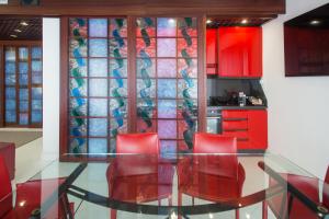 a kitchen with red chairs and a glass table at Verona apt.65 in Verona