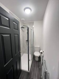 łazienka z prysznicem, toaletą i drzwiami w obiekcie Stylish 5 bedroom /7bed apartment w mieście Seacombe