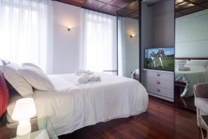 a bedroom with a white bed and a television at Verona apt.65 in Verona