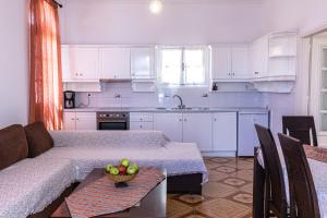 a kitchen with a couch and a bowl of fruit on a table at Blue Life Hotel in Emboríon