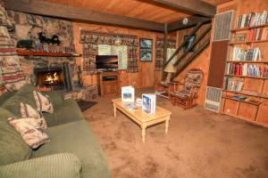a living room with a couch and a fireplace at Cardinal Ridge - Rustic cabin with stellar outdoor features! Wrap-around deck and large yard! in Big Bear City