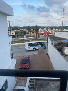 un bus garé sur un parking avec une voiture dans l'établissement Hotel Magnolia, à Tampico