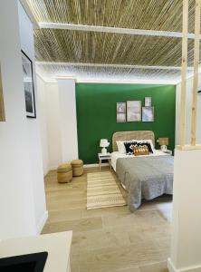 - une chambre avec un lit et un mur vert dans l'établissement casa Albufera junior, à Valence