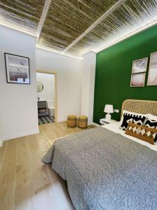 um quarto com uma parede verde e uma cama em casa Albufera junior em Valência