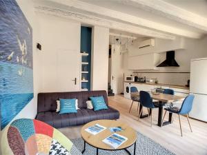 a living room with a couch and a table at Un balcon, au cœur du village in Cassis