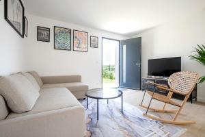 Les Coteaux de Toulouse في Aureville: غرفة معيشة بها أريكة وطاولة وتلفزيون