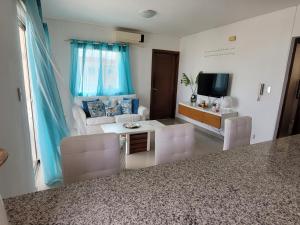a living room with a couch and a tv at Serena star3 in Punta Cana