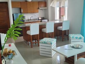 a kitchen with white chairs and a counter with a table at Serena star3 in Punta Cana