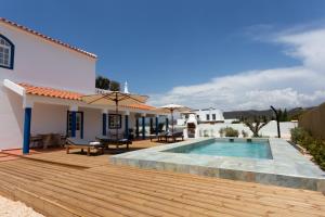 un patio trasero con piscina y terraza de madera en Casa da praia, en Carrapateira