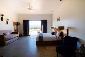 - une chambre avec un lit, un canapé et une fenêtre dans l'établissement Finca San Sebastian, à Valle de Guadalupe
