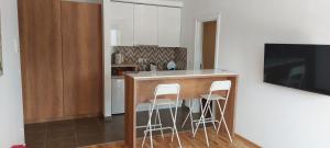 a kitchen with a counter and a bar with stools at Centar Crnjanski in Jagodina