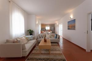 a living room with two couches and a coffee table at Casa da praia in Carrapateira