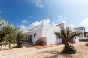 a white house with trees in front of it at Casa da praia in Carrapateira