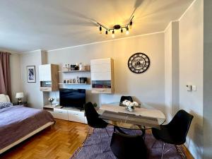 ein Schlafzimmer mit einem Tisch, einem Bett und einer Uhr in der Unterkunft Belgrade Apartment 2 in Zvezdara