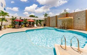 a large swimming pool with chairs and umbrellas at Hotel Miraval in Montería